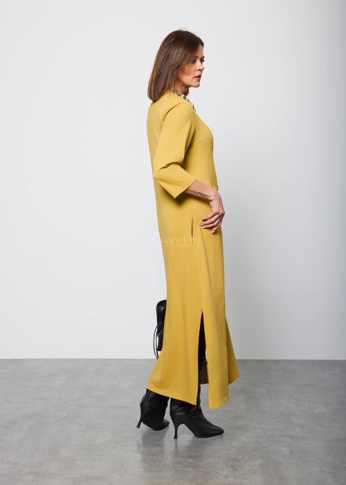 Damska sukienka midi w kolorze musztardowym, o prostym kroju z długimi rękawami i ozdobnym wiązaniem w talii po boku.