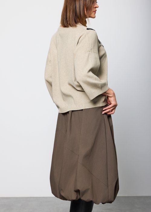 Damski sweter w kolorze jasnego beżu, o luźnym kroju z obniżoną linią ramion i długimi rękawami, prezentowany z tyłu i z profilu.