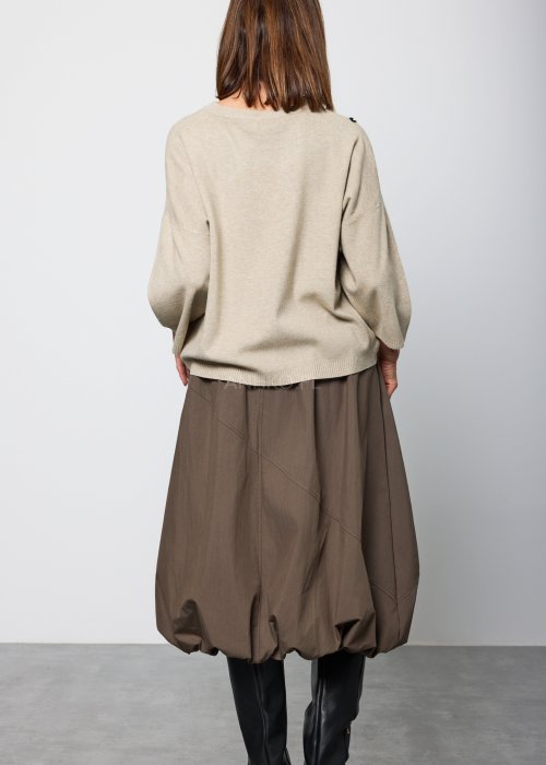 Damski sweter w kolorze jasnego beżu, o luźnym kroju z obniżoną linią ramion i długimi rękawami, prezentowany z tyłu i z profilu.