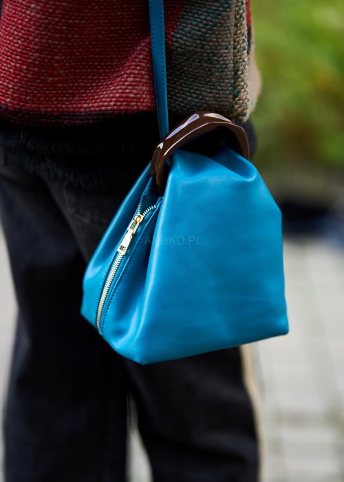 Niebieska torebka worek ze złotym zamkiem i ciemnymi uchwytami