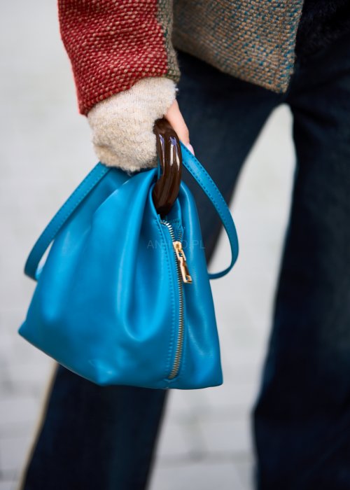 Niebieska torebka worek ze złotym zamkiem i ciemnymi uchwytami