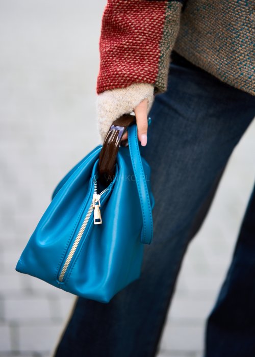 Niebieska torebka worek ze złotym zamkiem i ciemnymi uchwytami