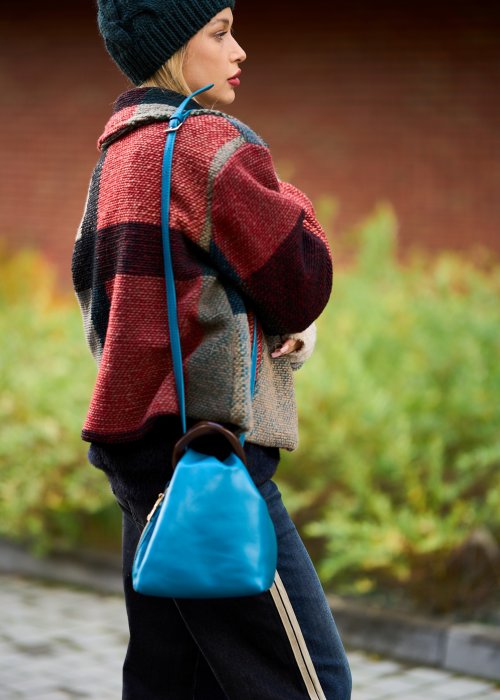 Niebieska torebka worek ze złotym zamkiem i ciemnymi uchwytami