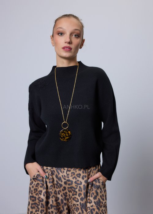 Czarny sweter o prostym, lekko luźnym kroju z długim rękawem i półgolfem; model wykonany z gładkiej dzianiny