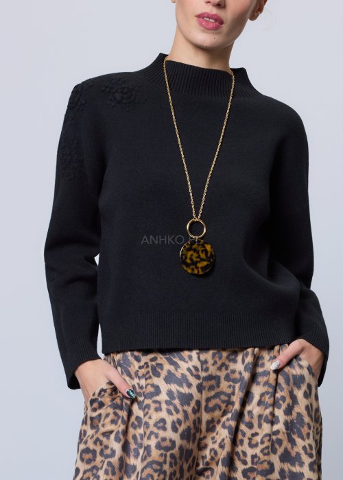 Czarny sweter o prostym, lekko luźnym kroju z długim rękawem i półgolfem; model wykonany z gładkiej dzianiny