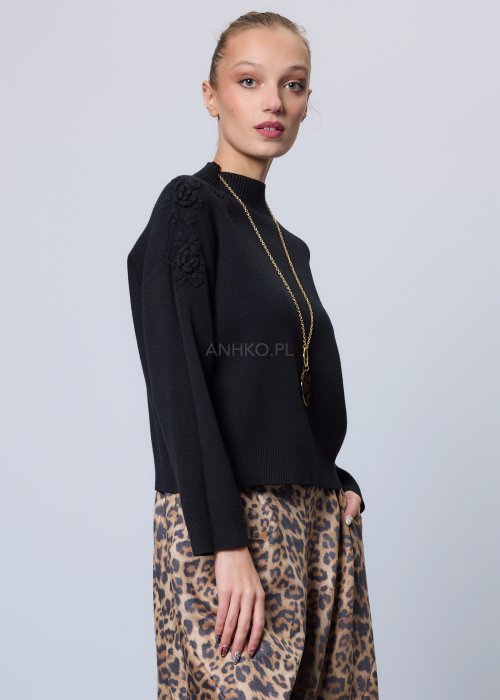 Czarny sweter o prostym, lekko luźnym kroju z długim rękawem i półgolfem; model wykonany z gładkiej dzianiny