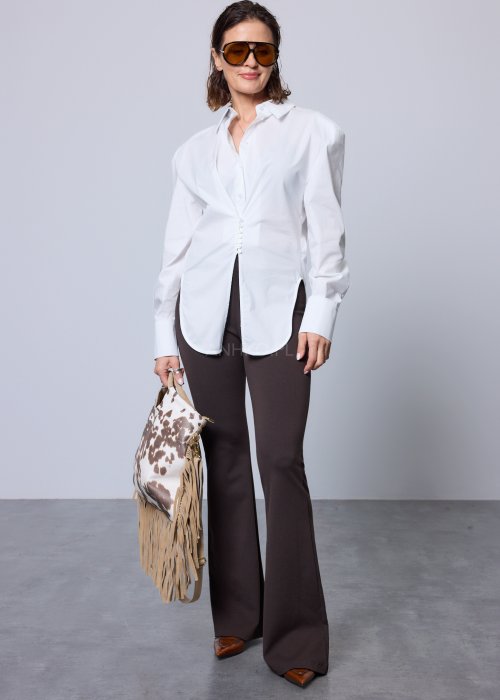 Biała koszula damska o klasycznym kroju z kołnierzykiem, zapinana na guziki, z długimi rękawami zakończonymi mankietami; delikatnie taliowana