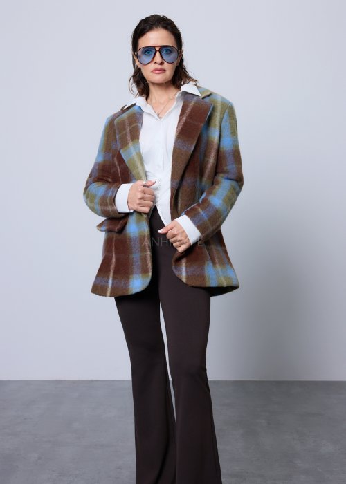 Biała koszula damska o klasycznym kroju z kołnierzykiem, zapinana na guziki, z długimi rękawami zakończonymi mankietami; delikatnie taliowana