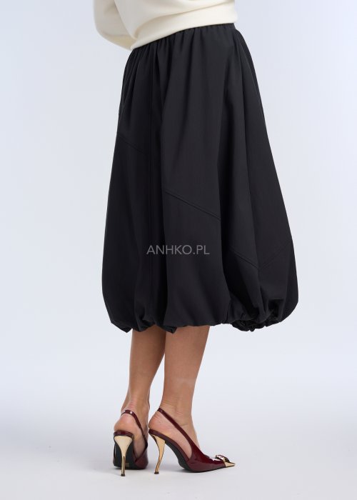 To czarna spódnica o długości midi, o balonowym fasonie. Ma luźno układającą się formę, z marszczeniem w pasie oraz ściągniętym dołem