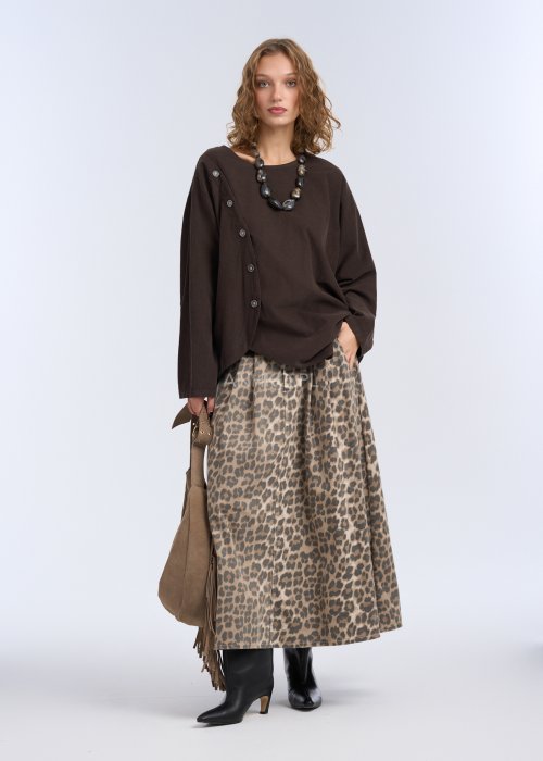 To luźna bluzka w kolorze ciemnego brązu, wykonana z lekkiego, miękko układającego się materiału.