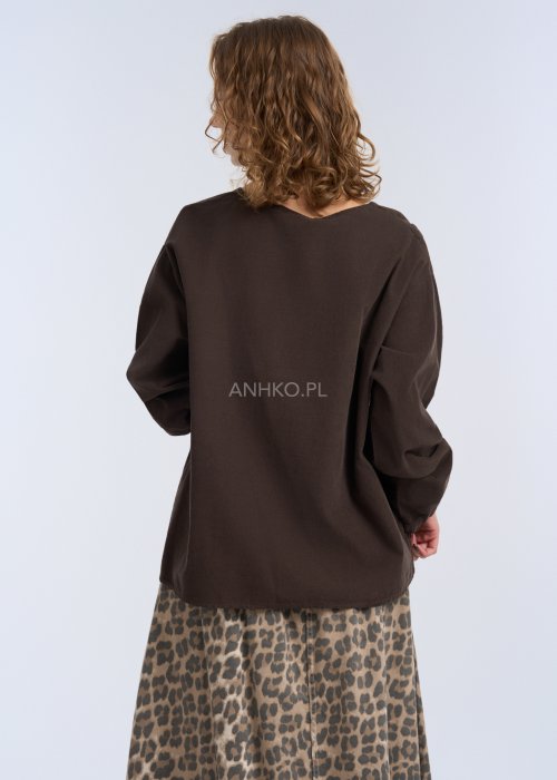 To luźna bluzka w kolorze ciemnego brązu, wykonana z lekkiego, miękko układającego się materiału.