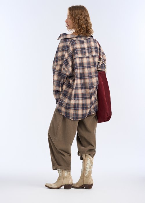 Są to luźne spodnie w kolorze brązowym, o komfortowym, swobodnym fasonie. Mają elastyczną talię z troczkiem do regulacji