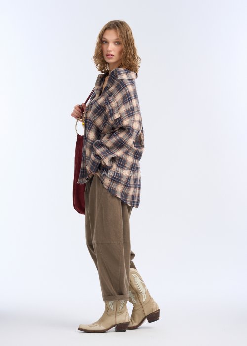 Są to luźne spodnie w kolorze brązowym, o komfortowym, swobodnym fasonie. Mają elastyczną talię z troczkiem do regulacji