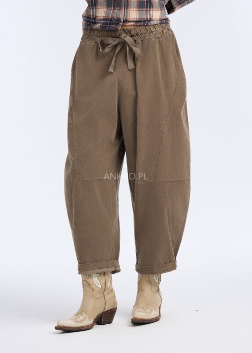 Są to luźne spodnie w kolorze brązowym, o komfortowym, swobodnym fasonie. Mają elastyczną talię z troczkiem do regulacji