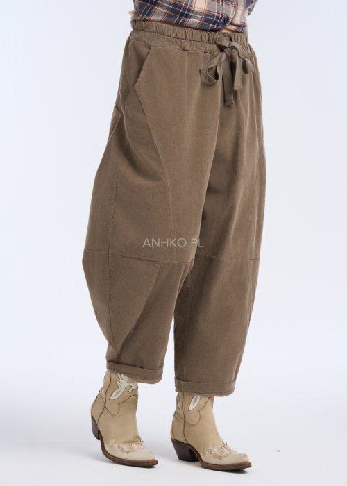 Są to luźne spodnie w kolorze brązowym, o komfortowym, swobodnym fasonie. Mają elastyczną talię z troczkiem do regulacji