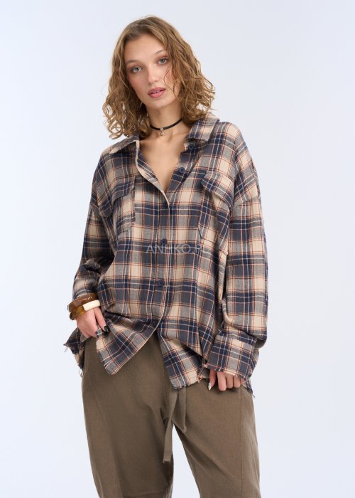 To luźna koszula w kratę w stonowanej kolorystyce beżu, granatu i ciepłego brązu. Ma oversize’owy fason, długie rękawy z mankietami oraz klasyczne zapięcie na guziki