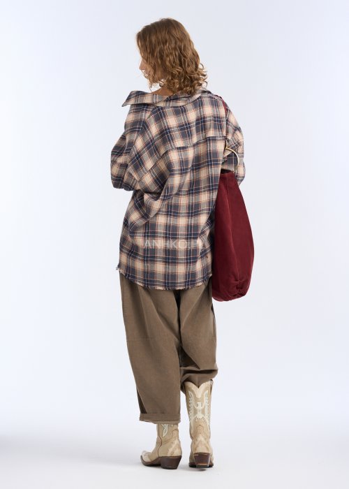 To luźna koszula w kratę w stonowanej kolorystyce beżu, granatu i ciepłego brązu. Ma oversize’owy fason, długie rękawy z mankietami oraz klasyczne zapięcie na guziki