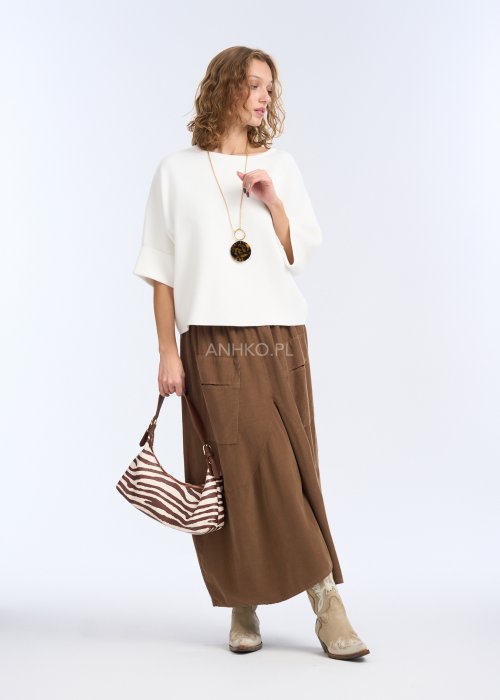 To biała, luźna bluzka o prostym, lekko oversize’owym kroju. Ma szerokie rękawy do łokcia, delikatnie rozszerzane, co nadaje jej lekkości i elegancji.