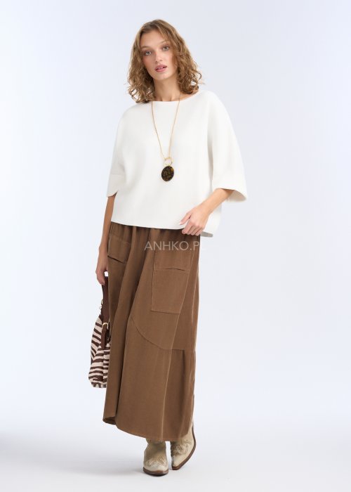 To biała, luźna bluzka o prostym, lekko oversize’owym kroju. Ma szerokie rękawy do łokcia, delikatnie rozszerzane, co nadaje jej lekkości i elegancji.