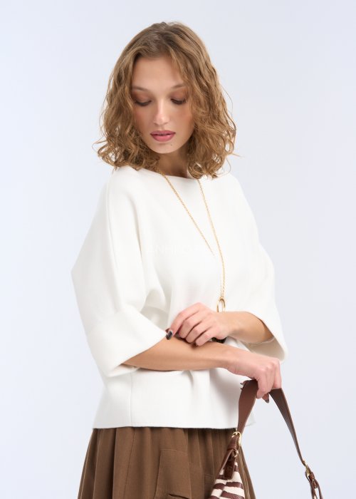 To biała, luźna bluzka o prostym, lekko oversize’owym kroju. Ma szerokie rękawy do łokcia, delikatnie rozszerzane, co nadaje jej lekkości i elegancji.
