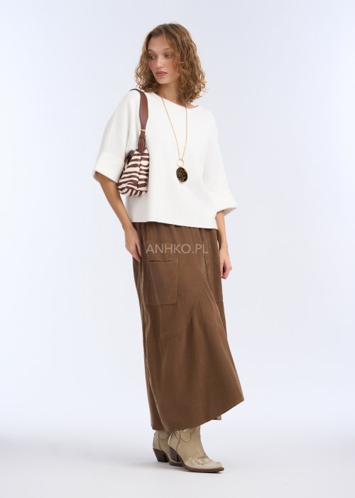 To biała, luźna bluzka o prostym, lekko oversize’owym kroju. Ma szerokie rękawy do łokcia, delikatnie rozszerzane, co nadaje jej lekkości i elegancji.