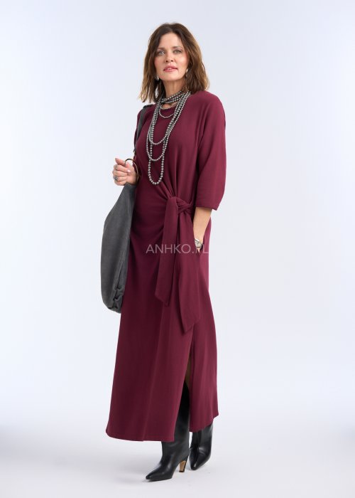 To sukienka maxi w głębokim, bordowym kolorze, o prostym, eleganckim kroju. Ma rękawy o długości 3/4 oraz okrągły dekolt