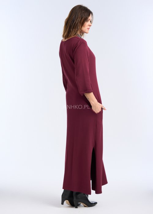 To sukienka maxi w głębokim, bordowym kolorze, o prostym, eleganckim kroju. Ma rękawy o długości 3/4 oraz okrągły dekolt