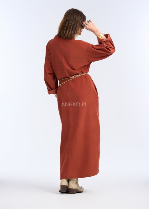 To sukienka maxi o koszulowym charakterze, wykonana z miękko układającej się, matowej tkaniny. Ma stójkę z krótkim zapięciem na guziki