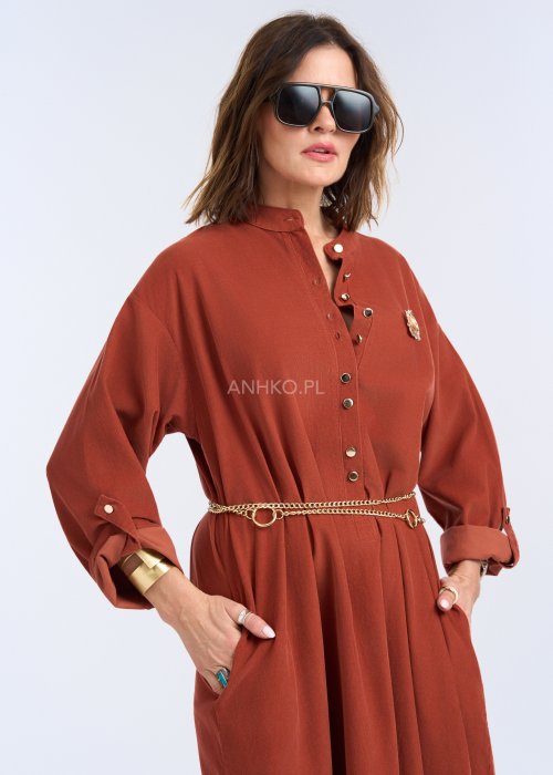 To sukienka maxi o koszulowym charakterze, wykonana z miękko układającej się, matowej tkaniny. Ma stójkę z krótkim zapięciem na guziki