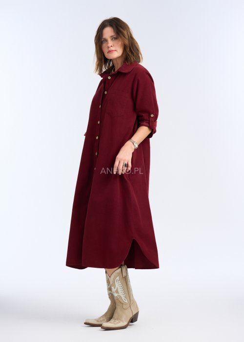 To sukienka midi/maxi o prostym, luźnym kroju, zapinana na całej długości na kontrastowe, jasne guziki, które nadają jej charakteru i przełamują jednolitą kolorystykę.