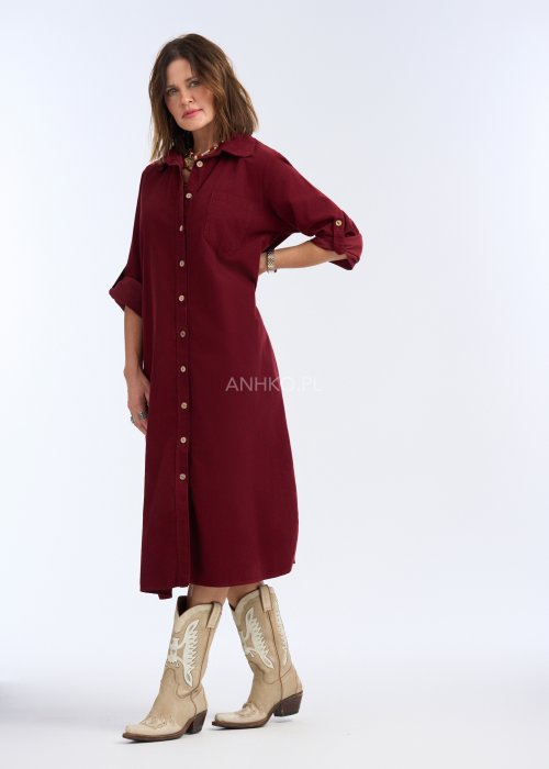 To sukienka midi/maxi o prostym, luźnym kroju, zapinana na całej długości na kontrastowe, jasne guziki, które nadają jej charakteru i przełamują jednolitą kolorystykę.