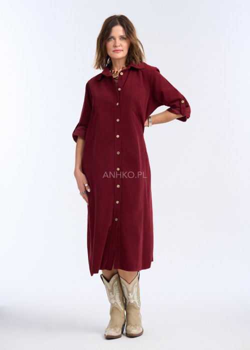 To sukienka midi/maxi o prostym, luźnym kroju, zapinana na całej długości na kontrastowe, jasne guziki, które nadają jej charakteru i przełamują jednolitą kolorystykę.