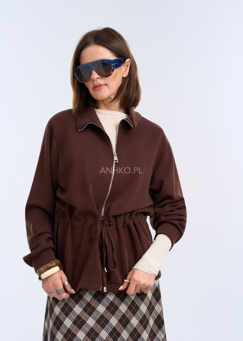 To krótka bluza w kolorze czekoladowego brązu, o luźnym kroju z delikatnie obniżoną linią ramion.