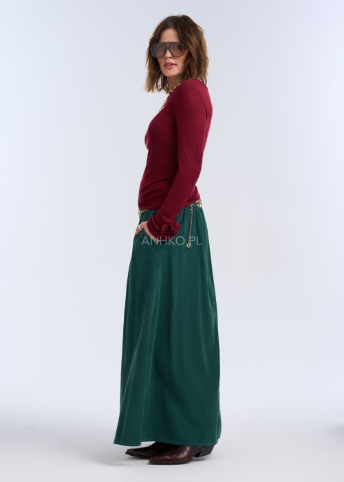 Bluzka z długim rękawem w głębokim odcieniu bordo. Fason jest smukły i blisko ciała, podkreślający sylwetkę, z gładką linią ramion i klasycznym, zabudowanym dekoltem.