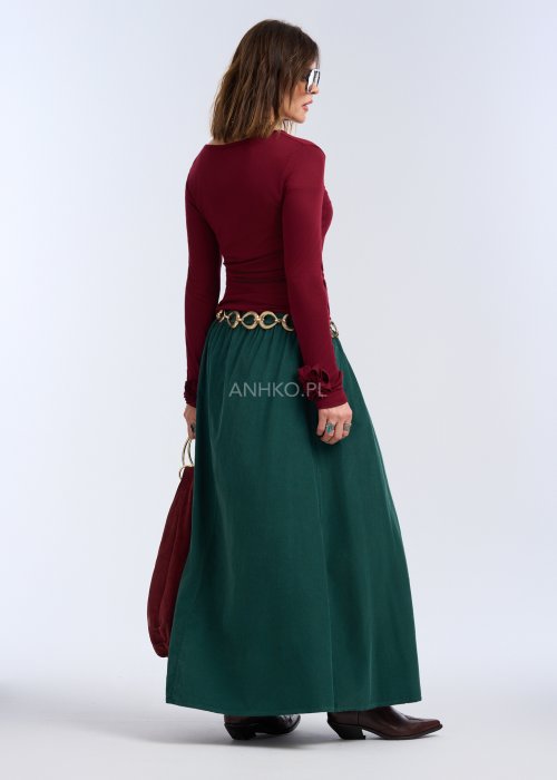 Bluzka z długim rękawem w głębokim odcieniu bordo. Fason jest smukły i blisko ciała, podkreślający sylwetkę, z gładką linią ramion i klasycznym, zabudowanym dekoltem.