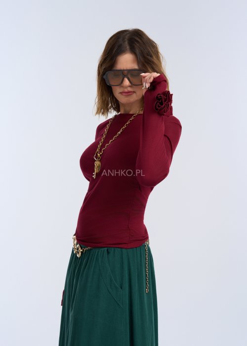 Bluzka z długim rękawem w głębokim odcieniu bordo. Fason jest smukły i blisko ciała, podkreślający sylwetkę, z gładką linią ramion i klasycznym, zabudowanym dekoltem.