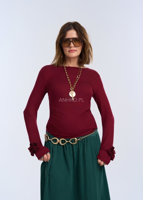 Bluzka z długim rękawem w głębokim odcieniu bordo. Fason jest smukły i blisko ciała, podkreślający sylwetkę, z gładką linią ramion i klasycznym, zabudowanym dekoltem.