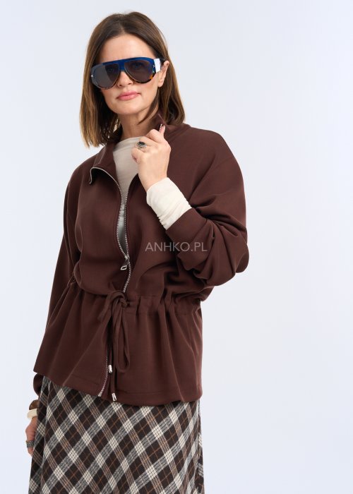 To krótka bluza w kolorze czekoladowego brązu, o luźnym kroju z delikatnie obniżoną linią ramion.