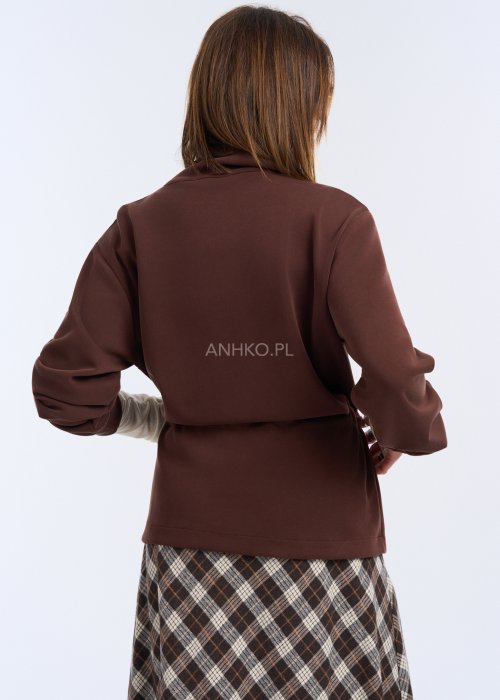 To krótka bluza w kolorze czekoladowego brązu, o luźnym kroju z delikatnie obniżoną linią ramion.
