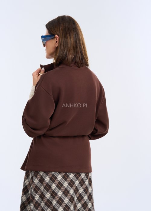 To krótka bluza w kolorze czekoladowego brązu, o luźnym kroju z delikatnie obniżoną linią ramion.