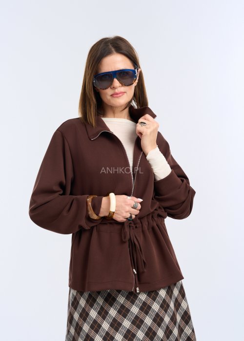 To krótka bluza w kolorze czekoladowego brązu, o luźnym kroju z delikatnie obniżoną linią ramion.