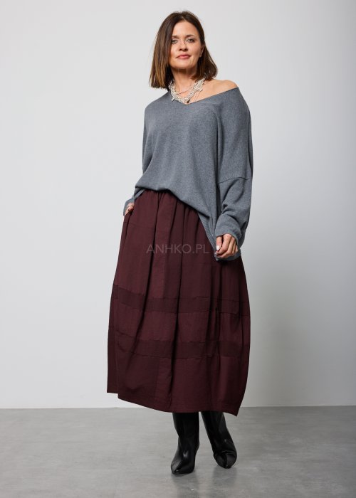 Luźny, szary sweter z długim rękawem i dekoltem w serek, noszony do burgundowej spódnicy