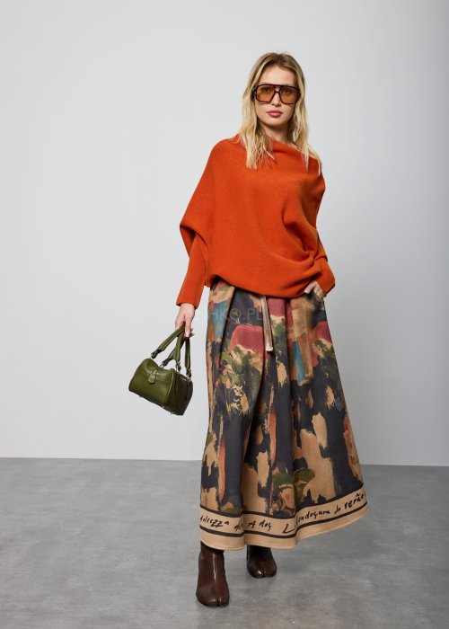 Ceglany sweter damski oversize o nietoperzowym kroju z asymetrycznym dołem, stylizacja miejska z dodatkami.