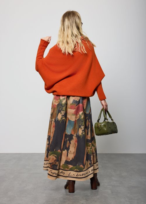 Ceglany sweter damski oversize o nietoperzowym kroju z asymetrycznym dołem, stylizacja miejska z dodatkami.