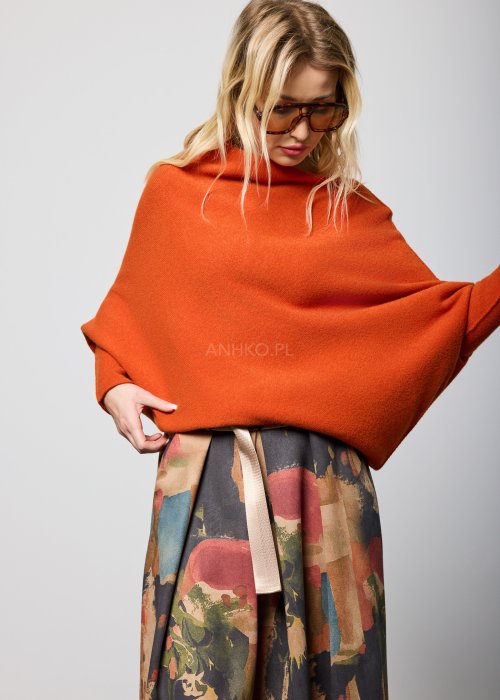 Ceglany sweter damski oversize o nietoperzowym kroju z asymetrycznym dołem, stylizacja miejska z dodatkami.