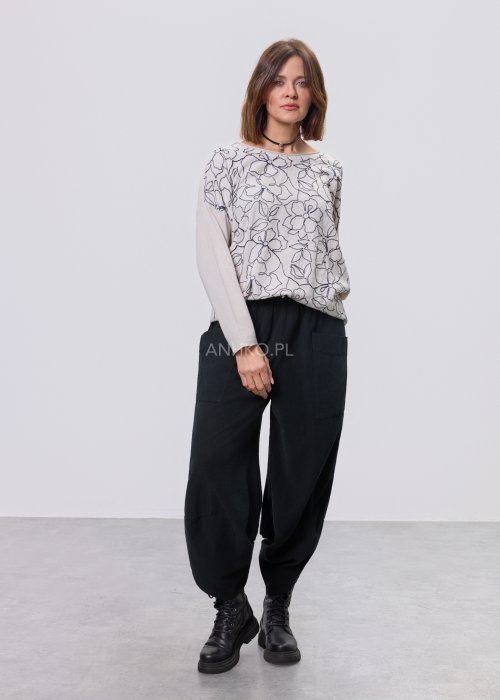 Jasna bluzka damska z długim rękawem, wykonana z lekkiej tkaniny, z dekoracyjnym haftem w kontrastowy kwiatowy wzór na przodzie; prosty, swobodny krój, okrągły dekolt, stylizacja na jasnym tle