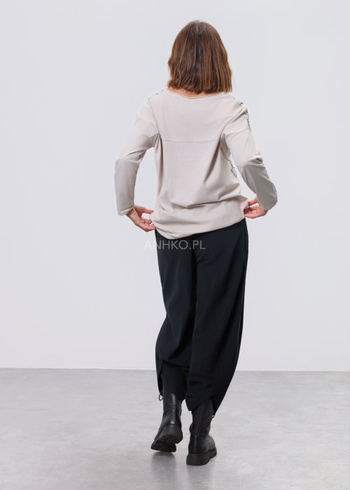 Jasna bluzka damska z długim rękawem, wykonana z lekkiej tkaniny, z dekoracyjnym haftem w kontrastowy kwiatowy wzór na przodzie; prosty, swobodny krój, okrągły dekolt, stylizacja na jasnym tle