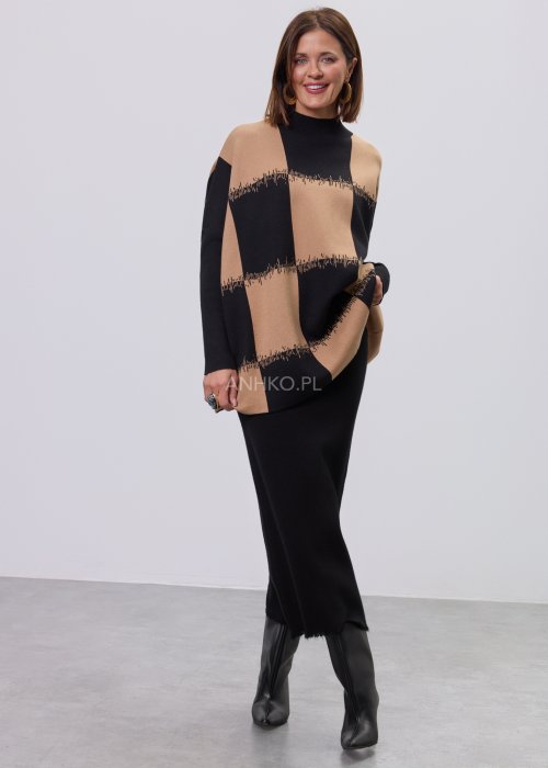 Beżowo-czarna damska tunika z dzianiny o luźnym kroju, z geometrycznym wzorem pasów i półgolfem, długie rękawy, prezentowana na modelce na jasnym tle