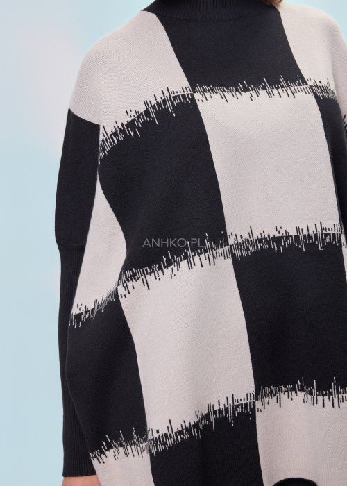 Czarno-ecru damska tunika dzianinowa o luźnym kroju, z półgolfem i długimi rękawami, w geometryczny wzór pasów z delikatnym motywem graficznym, prezentowana na modelce na jasnym tle