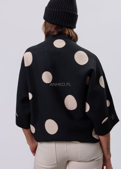Czarny damski sweter o luźnym kroju z półgolfem i rękawami 3/4, ozdobiony kontrastowym wzorem beżowych kropek, prezentowany na modelce na jasnym tle